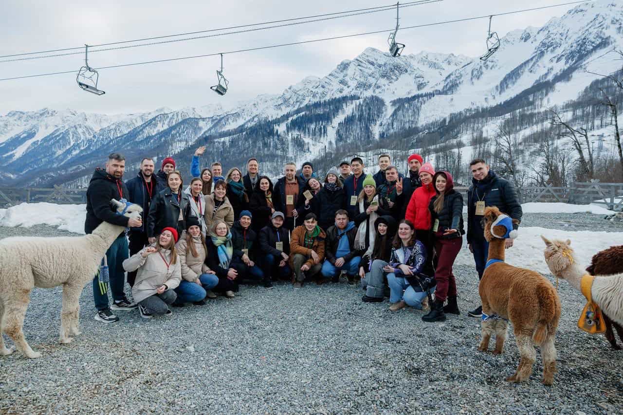 Kim Gleb Irlamovich and other participants against the background of snowy mountains and llamas.